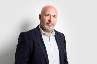 Tim Wright, partner and co-lead of the technology sector group at UK law firm Fladgate with a bard and suit but no tie