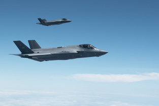 Two U.S. Air Force F-35 aircraft flying against a blue sky 