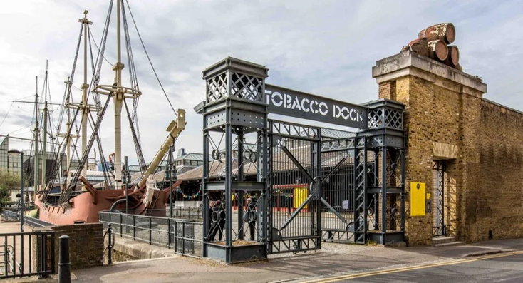 The gates to Tobacco Dock with an old ship visible through them The gates to Tobacco Dock with an old ship visible through them