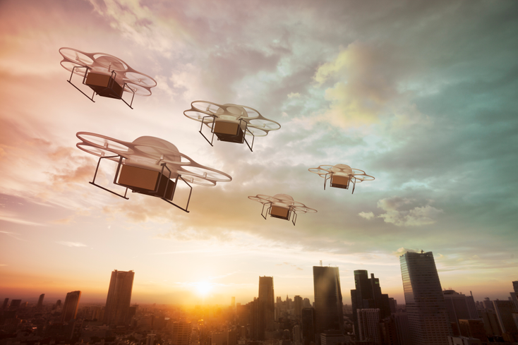 Delivery drones flying at sunset