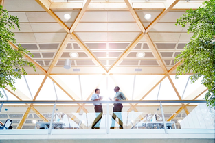 Colleagues talk on a balcony in a modern office