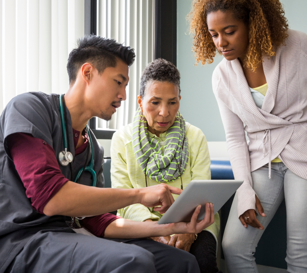 Male nurse consulting with two females 