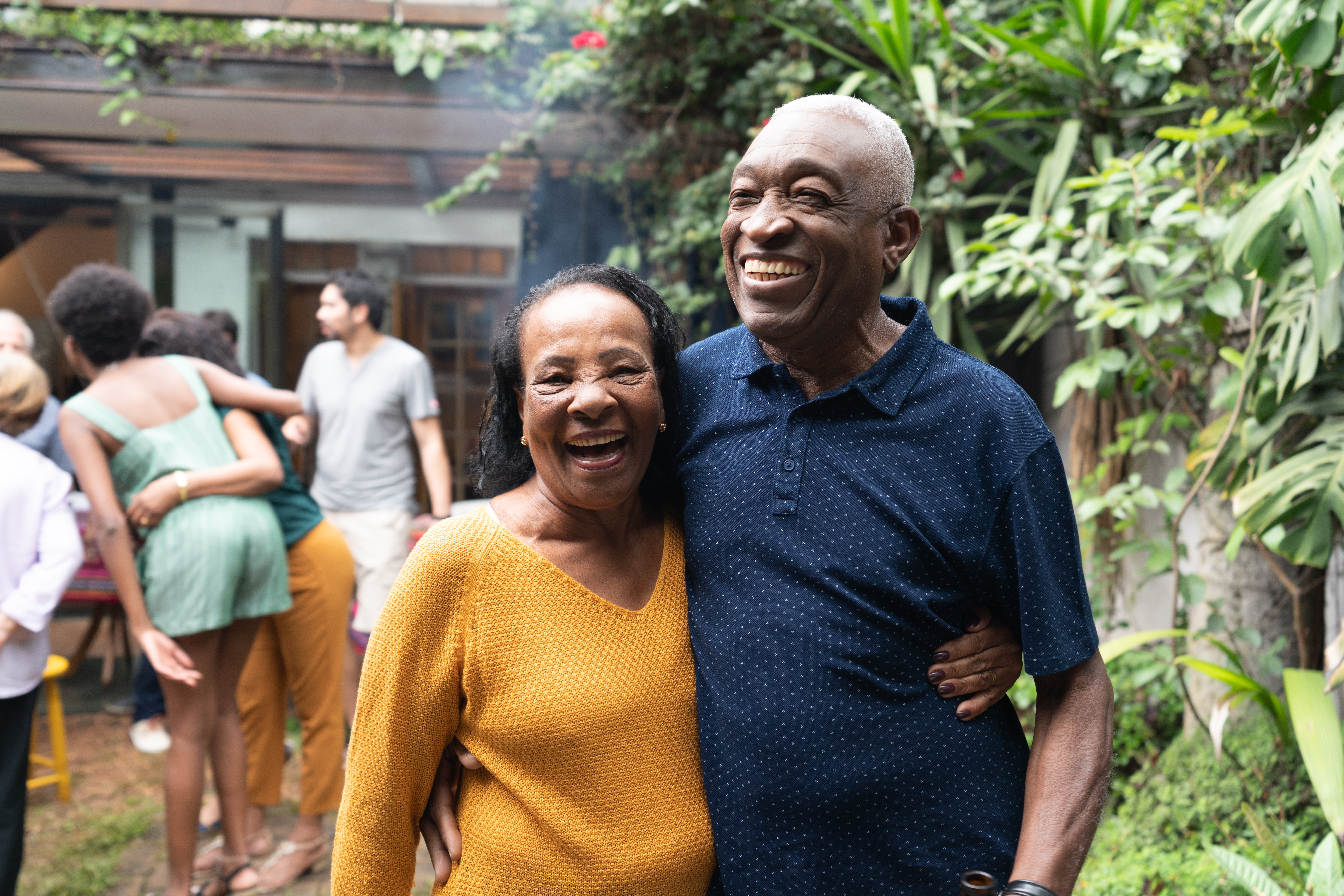 An older woman and man holding each other during a gathering