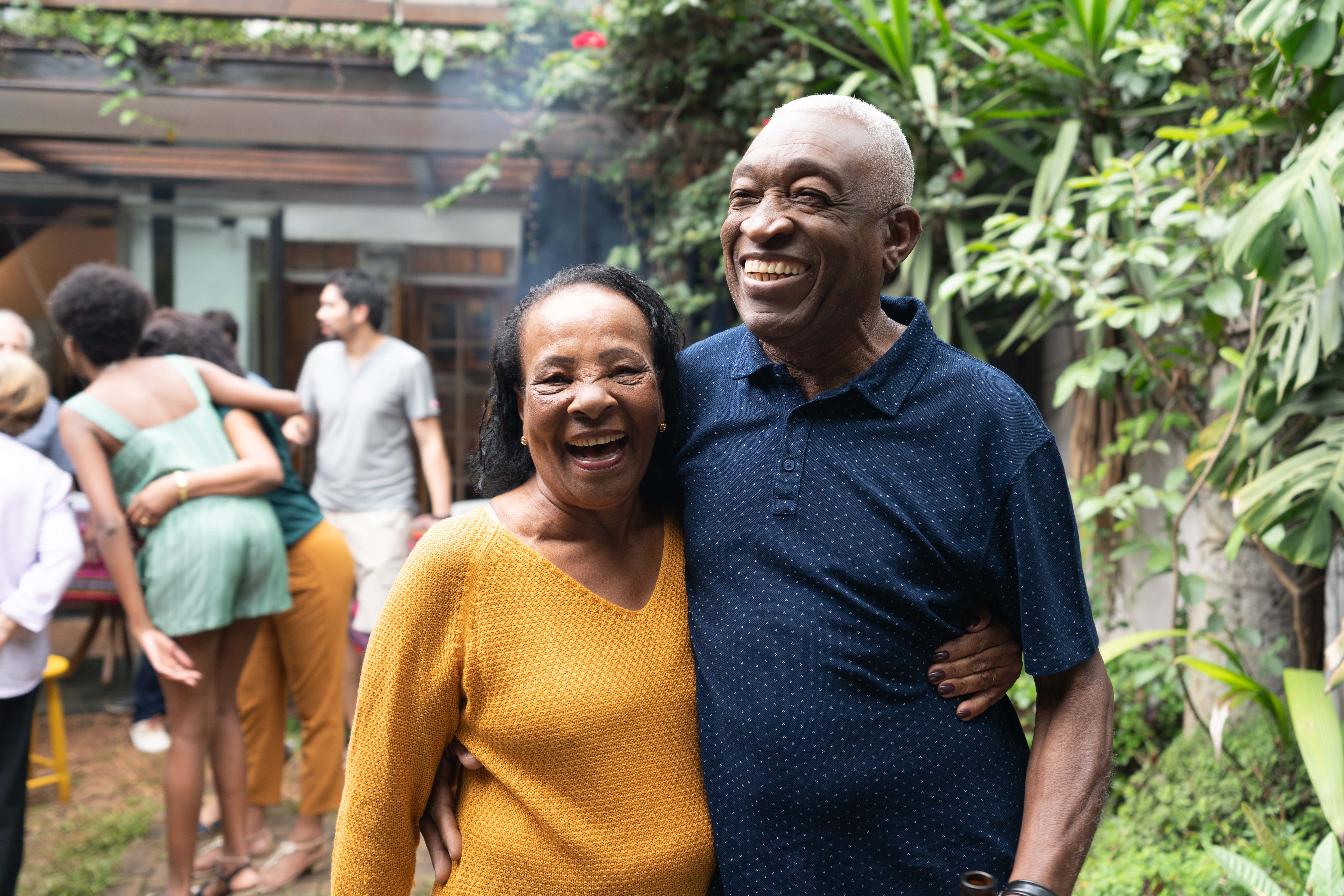 An older woman and man holding each other during a gathering
