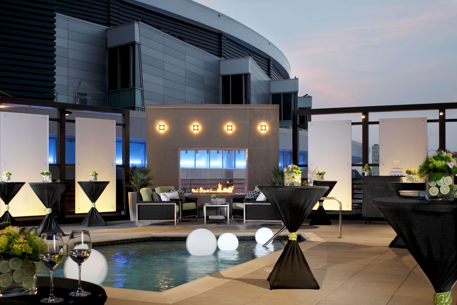 The atmospheric pool area of Hyatt House is in the foreground. There's a fire pit in the background.