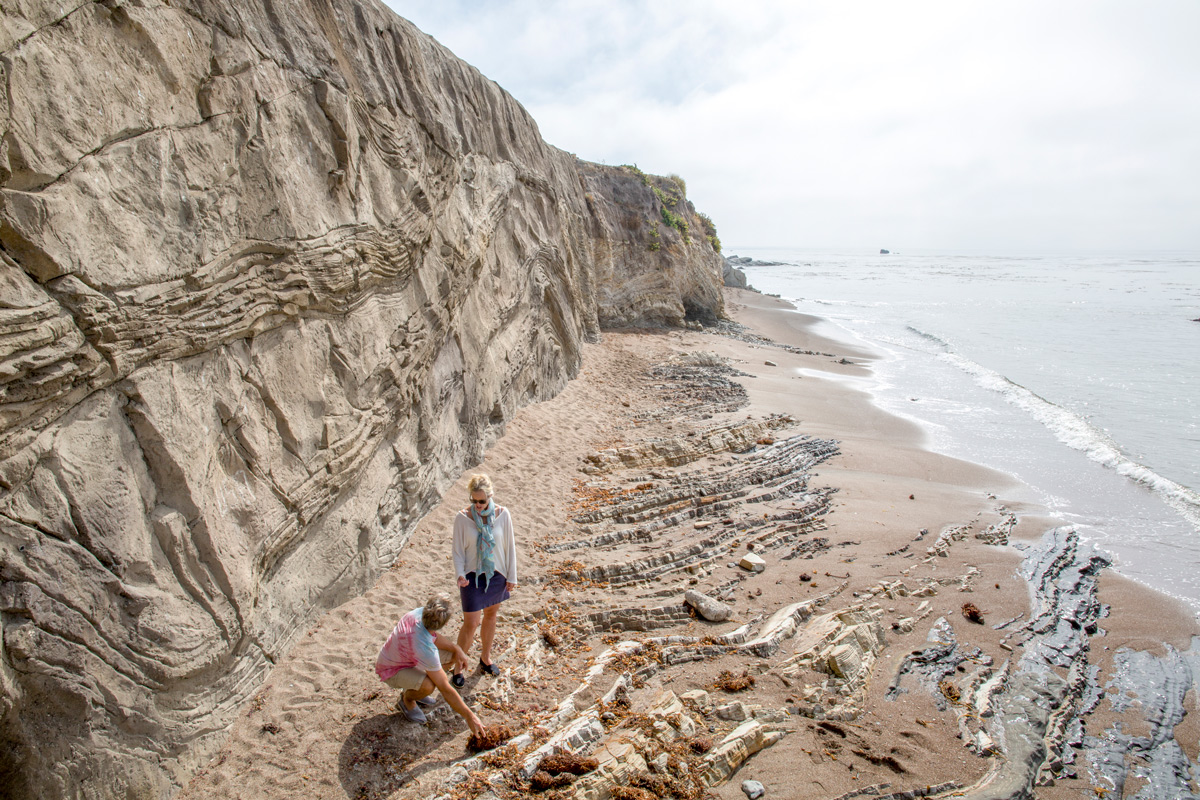 A woman walks on the beach in San Luis Obispo, California, soaking up the sun and sea breeze.