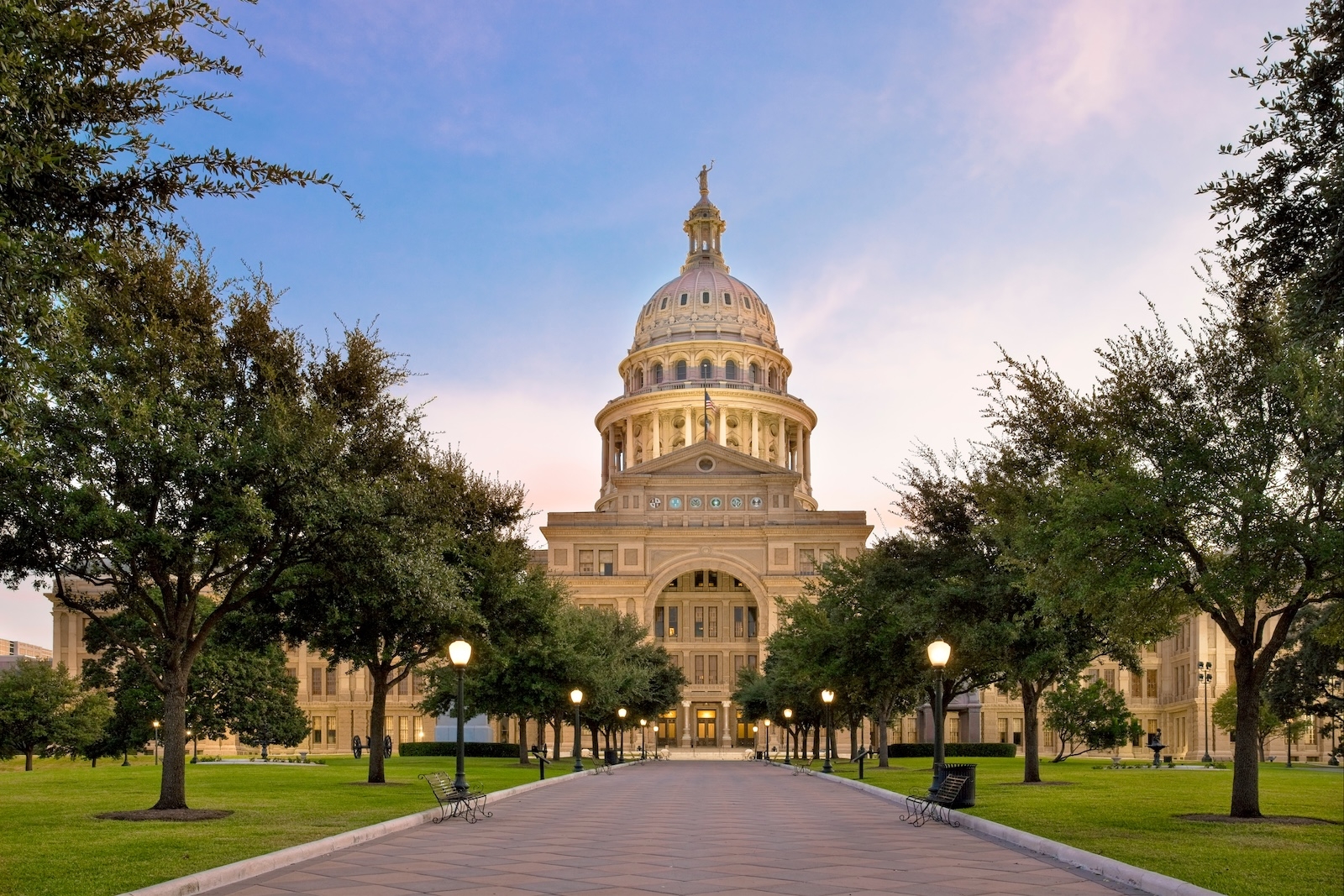 The Texas State Capitol building in Austin, showcasing its distinctive dome and architectural grandeur against a clear sky.