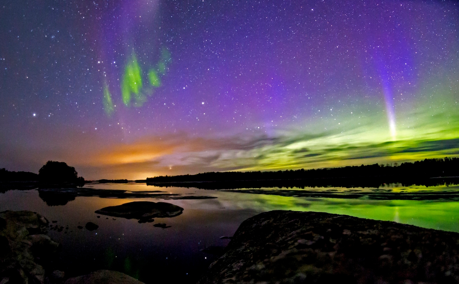 The Northern Lights light up the sky boldly, releasing bright colors such as orange, green and purple 