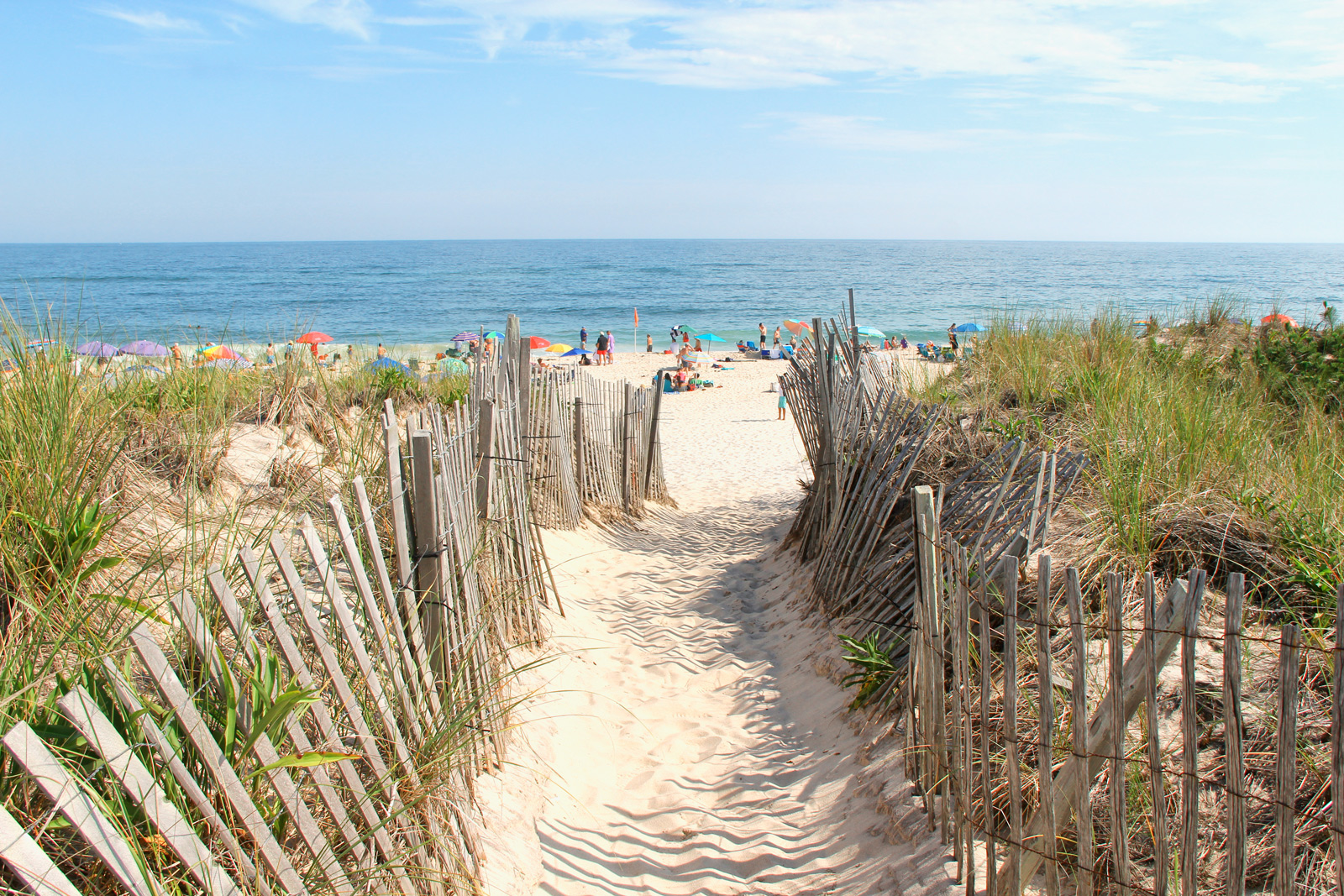  A serene path winding through the Hamptons, leading directly to the tranquil ocean waves.