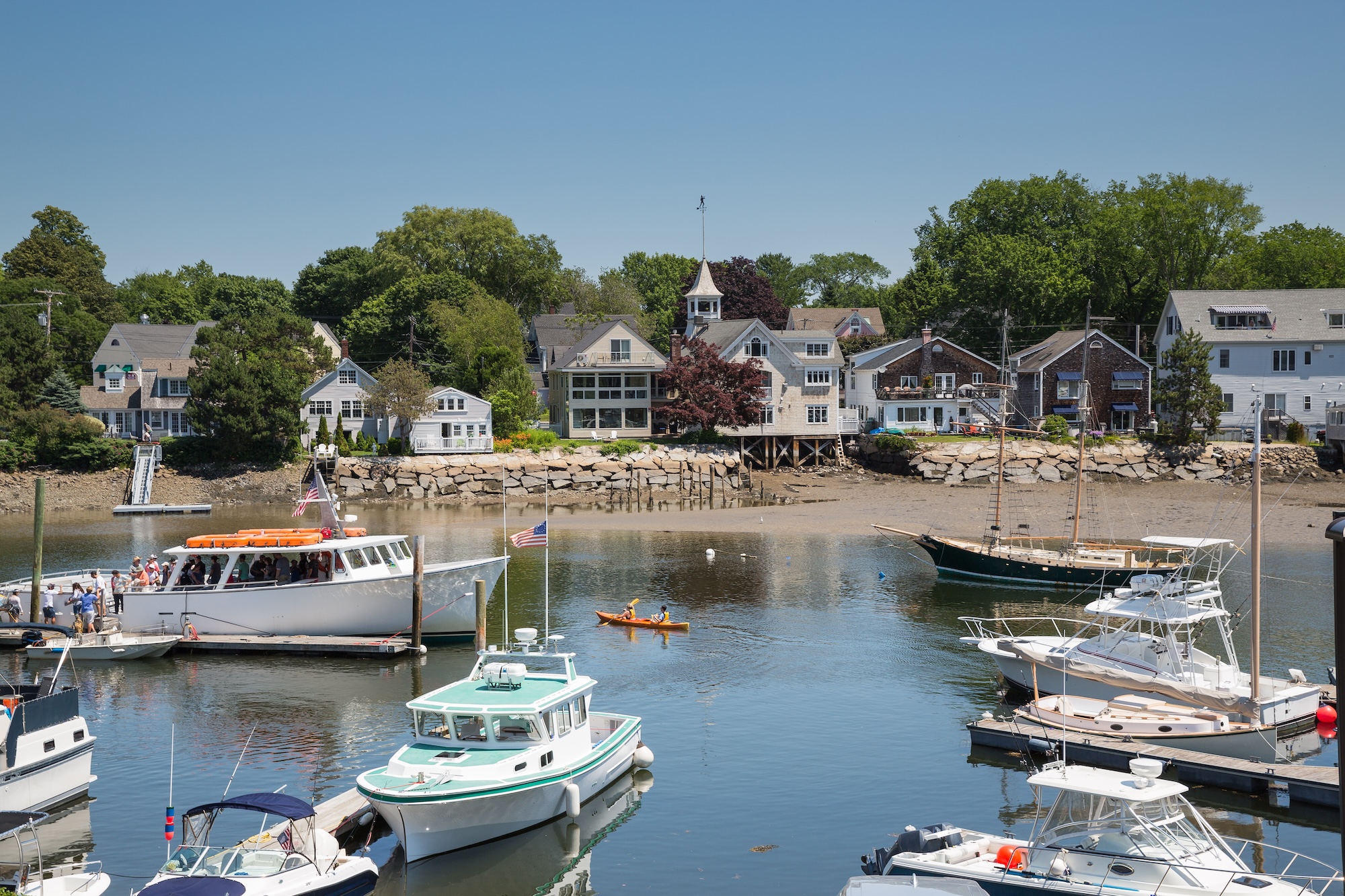 Boats gently bobbing in the serene waters of Kennebunkport, Maine, surrounded by picturesque scenery.