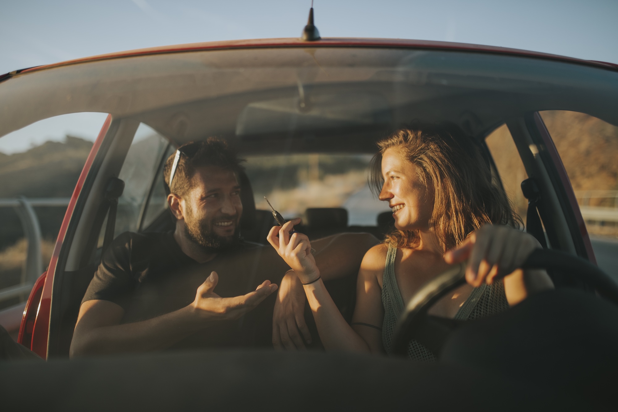 Een vrouw en een man zitten ontspannen in een auto