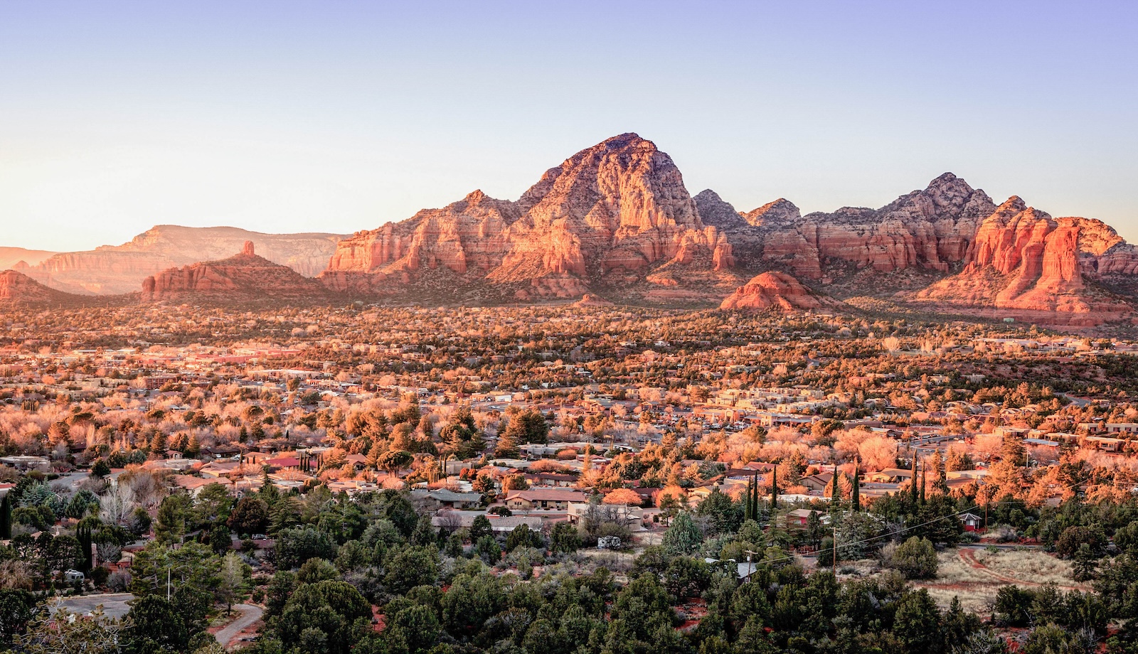 Sunset over the red rocks of Sedona, Arizona, casting warm hues across the rugged landscape – perfect for a Friendsgiving getaway
