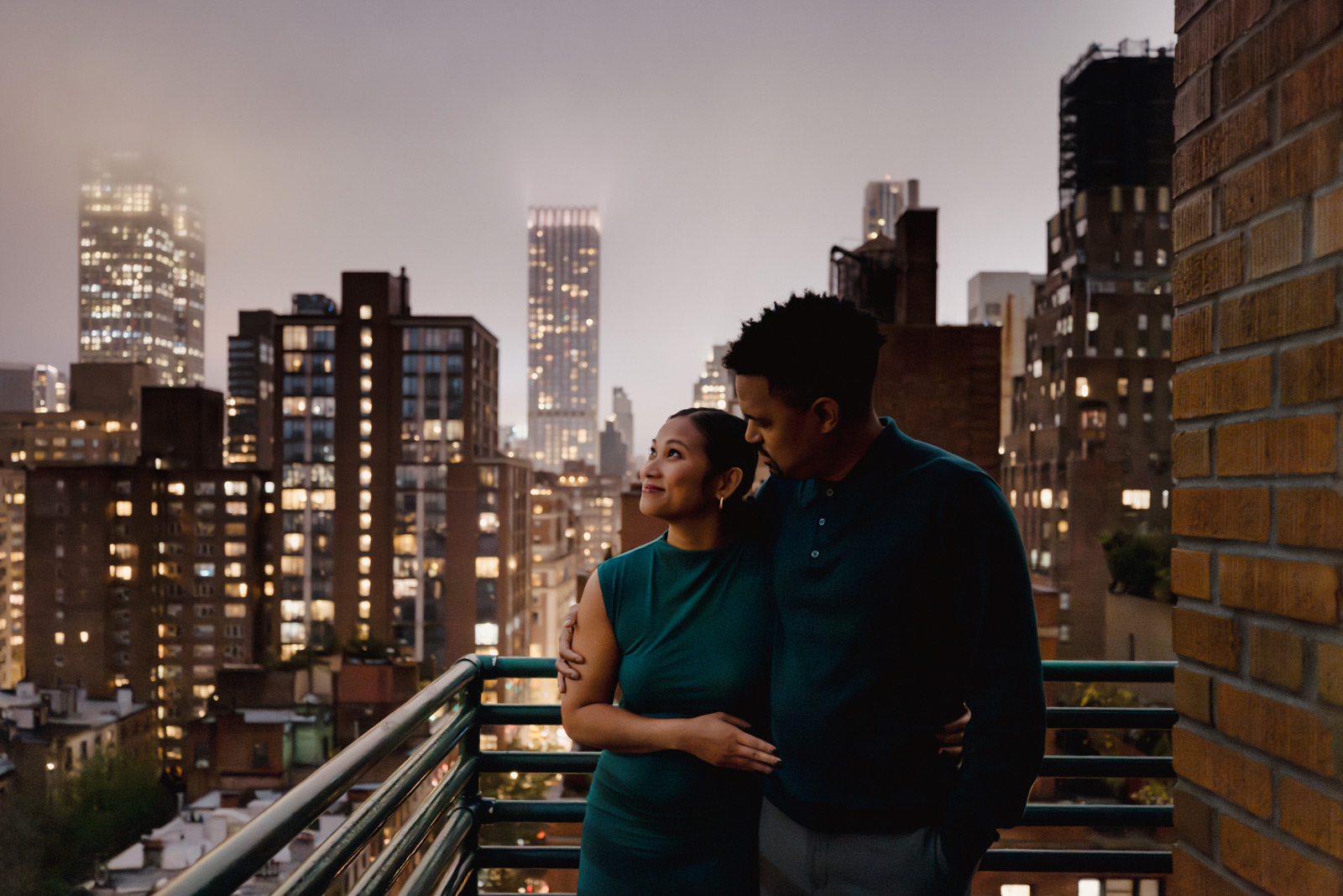 A couple joyfully poses in a romantic engagement session amidst the iconic skyline of New York City.