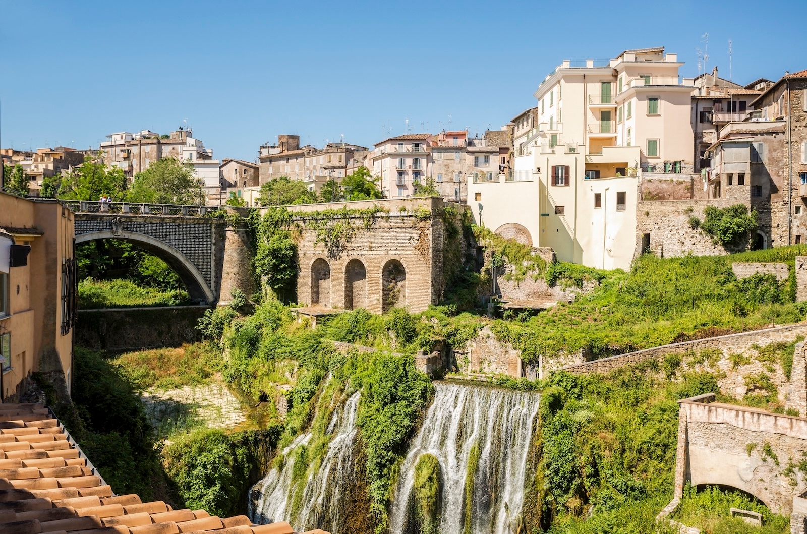 Scenic view of Villa Gregoriana in Tivoli, Italy, showcasing its historic architecture and surrounding landscape that includes waterfalls and greenery