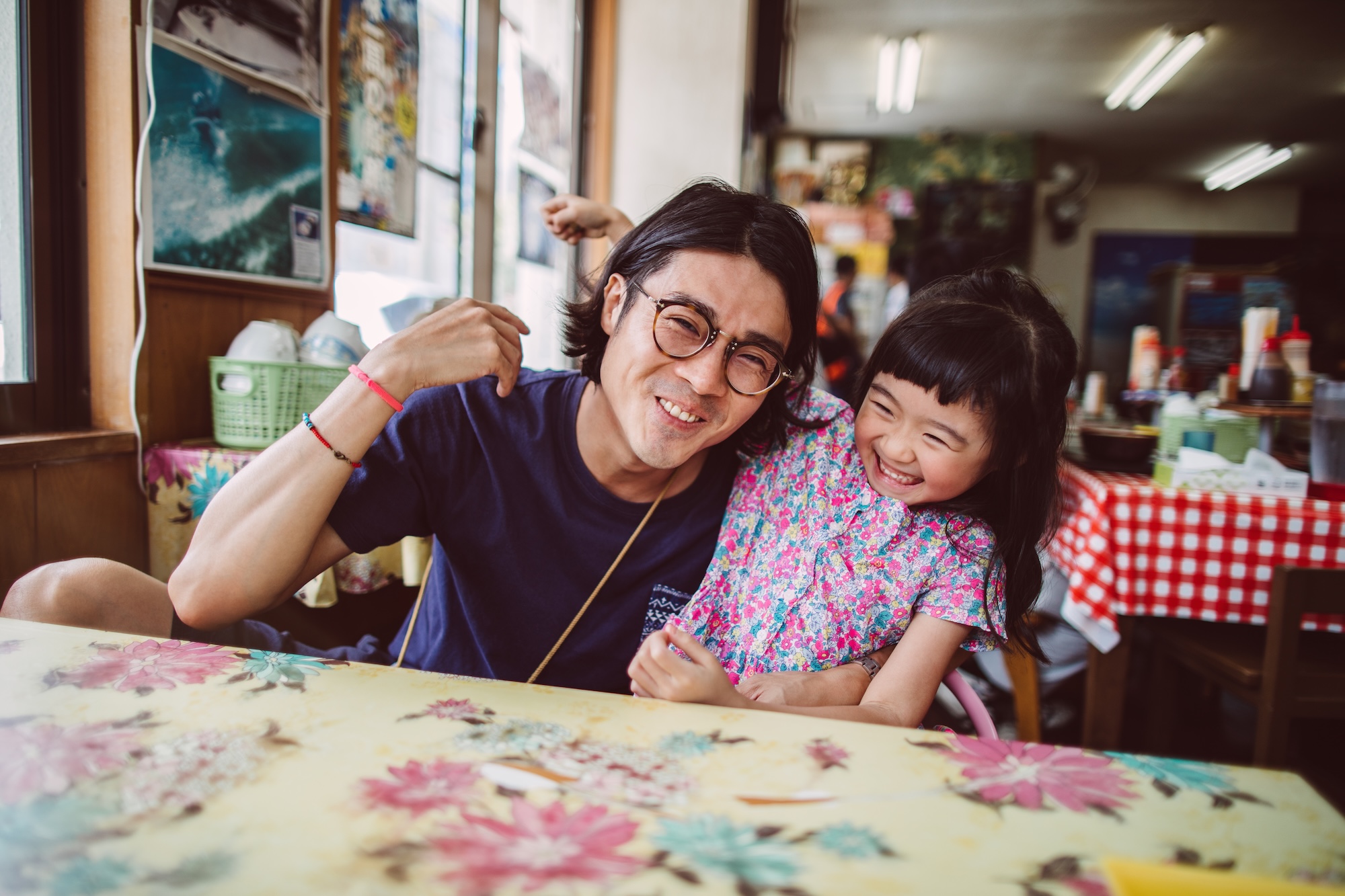 A man and a little girl sit at a table in a NOLA restaurant