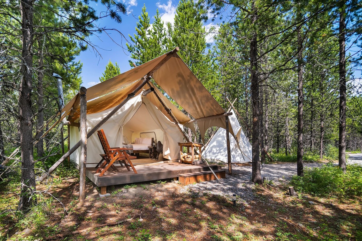 A tent set on a wooden deck in the serene woods of Under Canvas Glacier, Montana, perfect for a nature getaway.