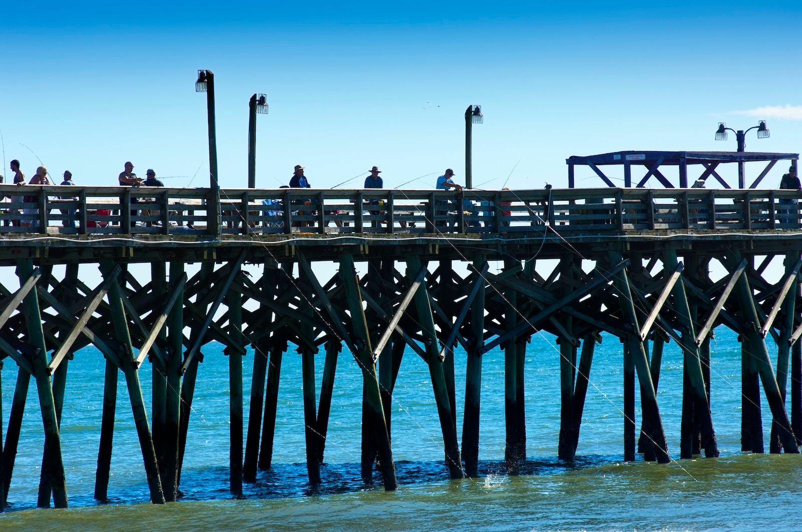 A busy pier in Surfside with several people enjoying the view and activities along the waterfront