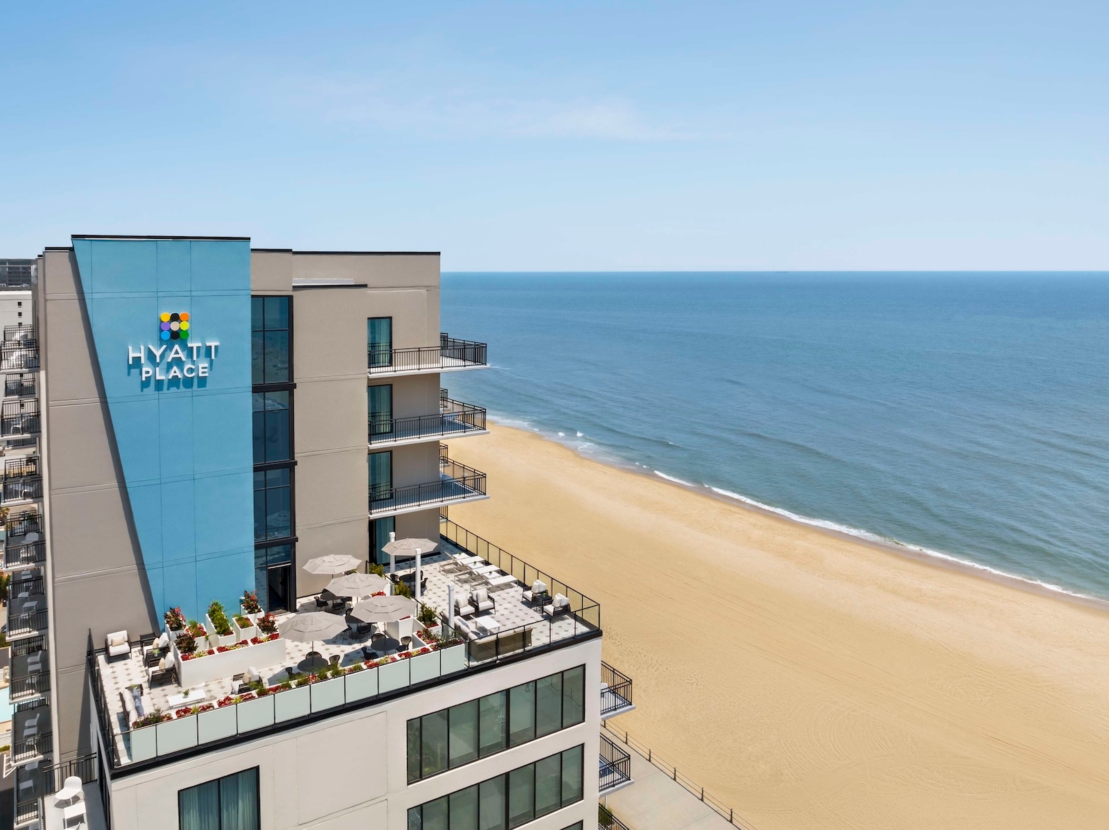 Hyatt Place hotel in Virginia Beach, with a tan facade and inviting entrance, surrounded by the beach