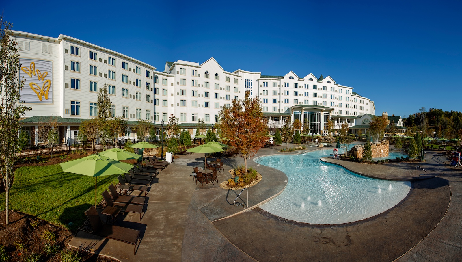 Dollywood's DreamMore Resort features a pool surrounded by lawn chairs, inviting relaxation in Tennessee's scenic setting