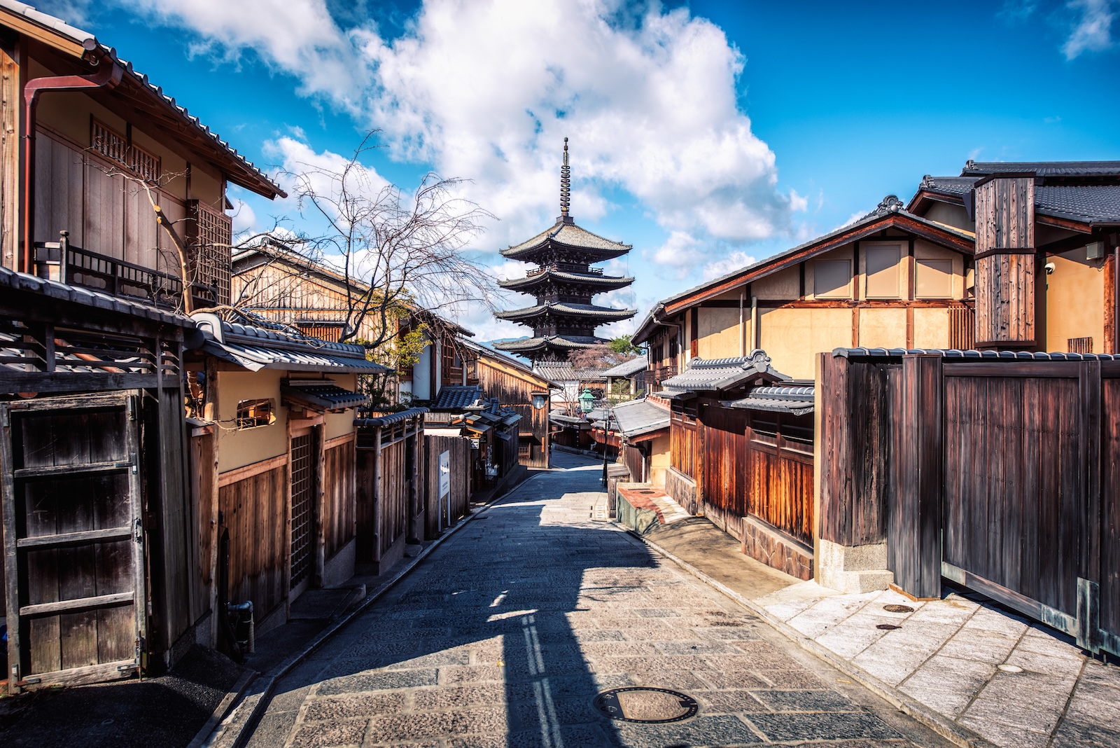 A picturesque narrow street in Higashiyama, featuring a pagoda rising in the background
