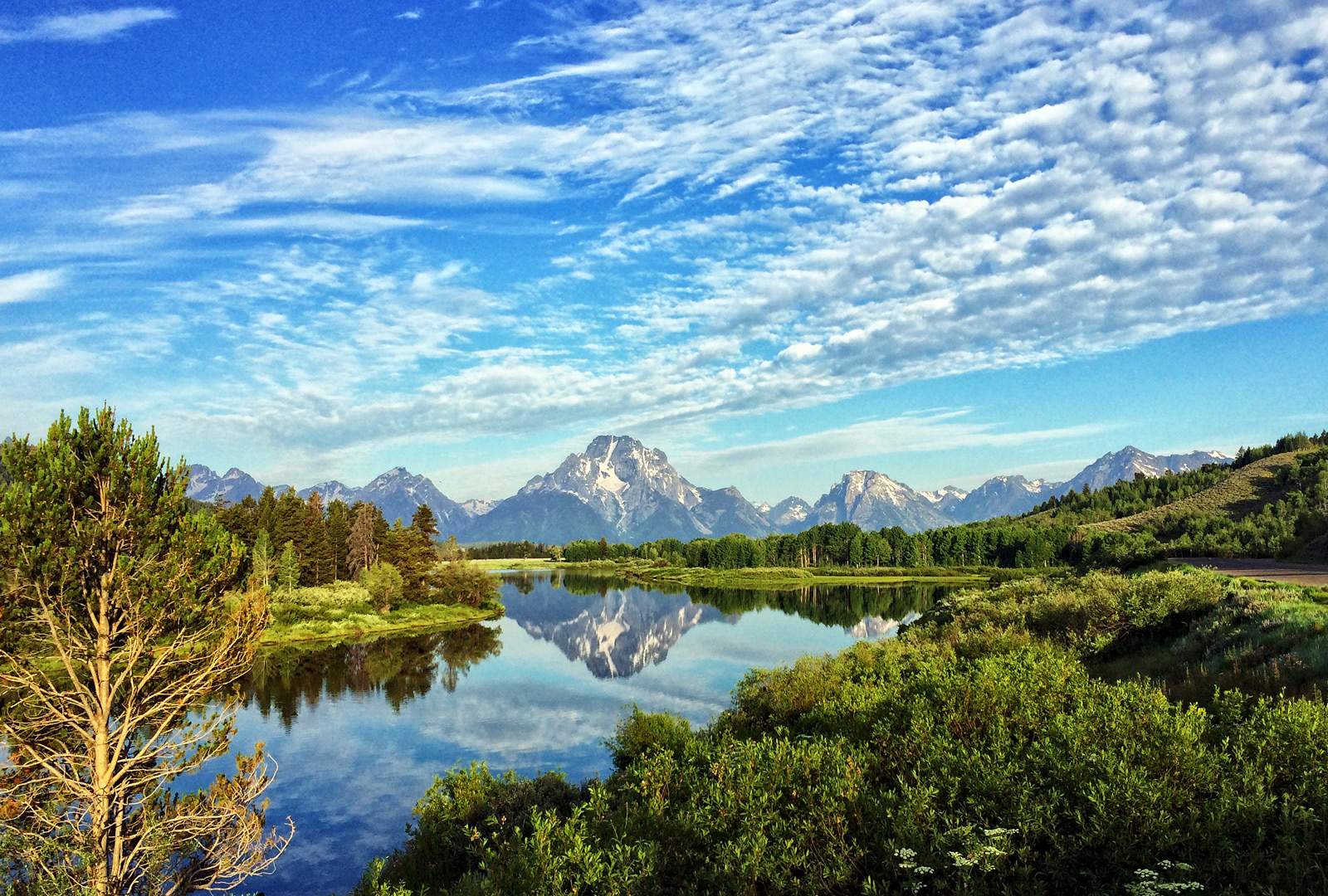 Reflection of the Grand Teton Mountains in the serene waters of Jackson Hole, Wyoming, showcasing nature's beauty.