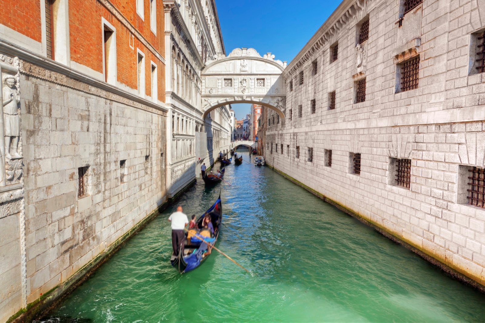 A gondola glides through the serene Canal of Sighs in Venice, Italy, surrounded by historic architecture in Castello