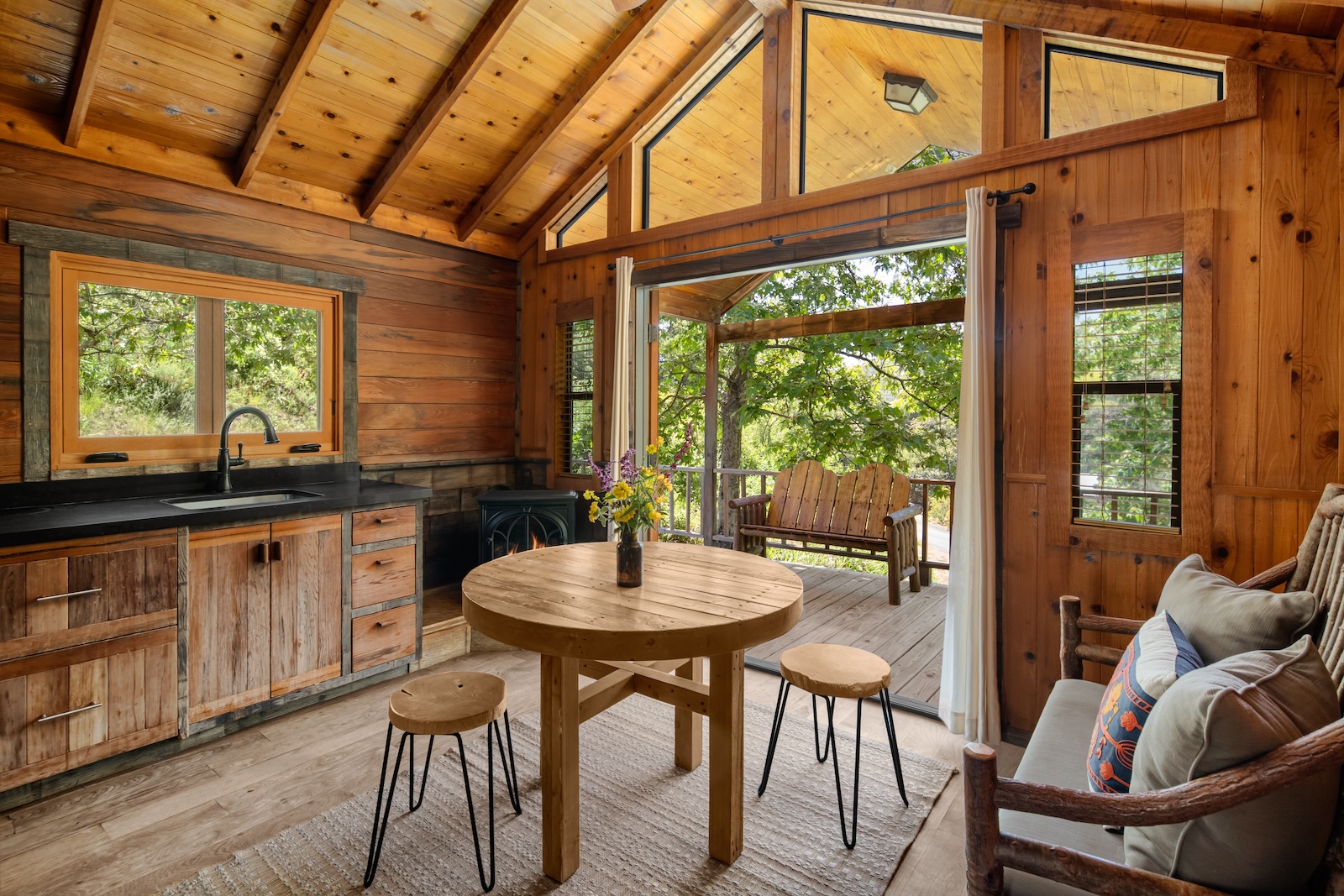 Cozy cabin kitchen and dining area in El Capitan Canyon, California, featuring rustic decor and warm, inviting ambiance.