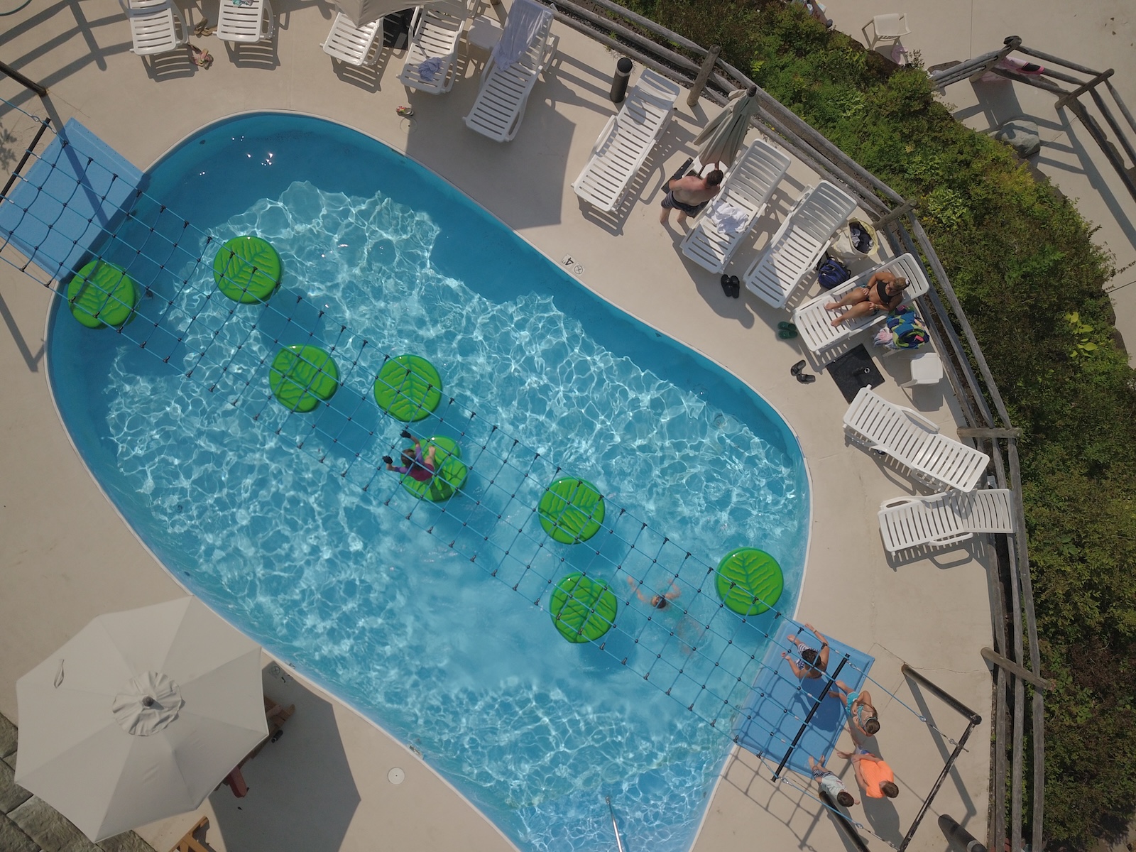 Aerial view of a pool at Smugglers' Notch Resort in Vermont, featuring several people enjoying the pool area