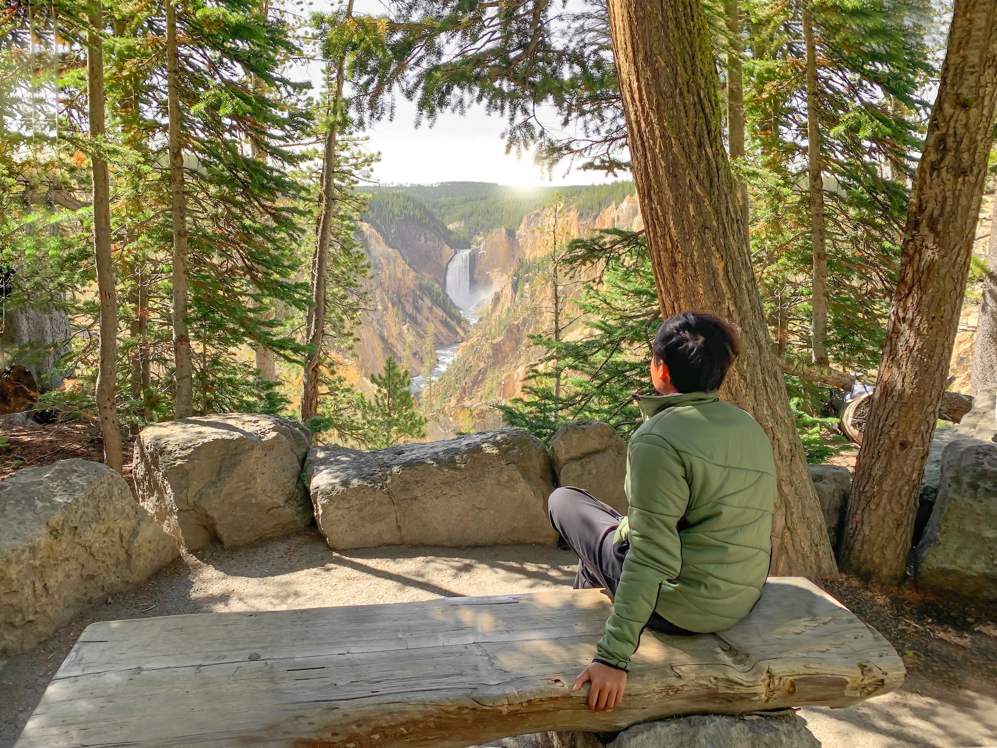 A boy sits looking out to Yellowstone National Park