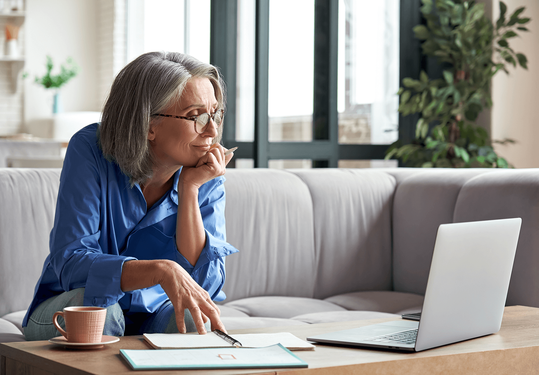 a woman taking notes during a virtual meeting.png