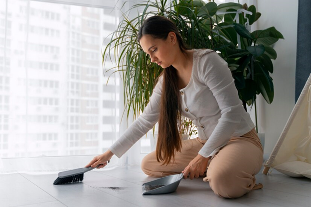 A lady dusting the floor