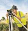 A surveyor looks through a lens