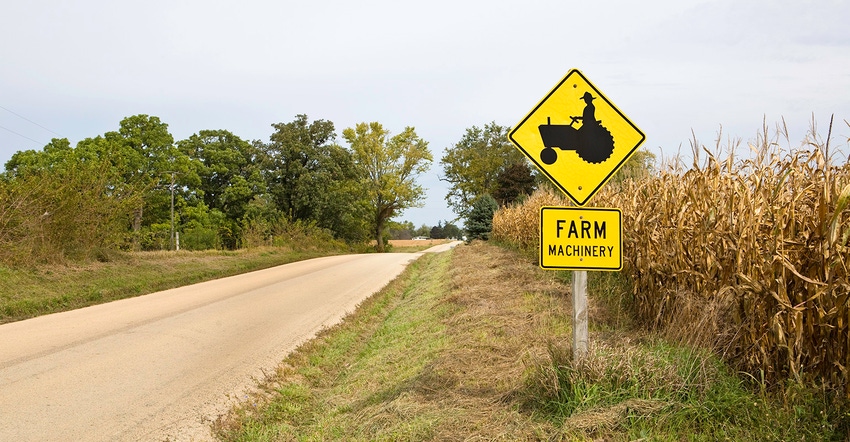Farm machinery sign along a country road