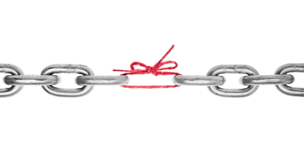 A steel chain with one link replaced by red string