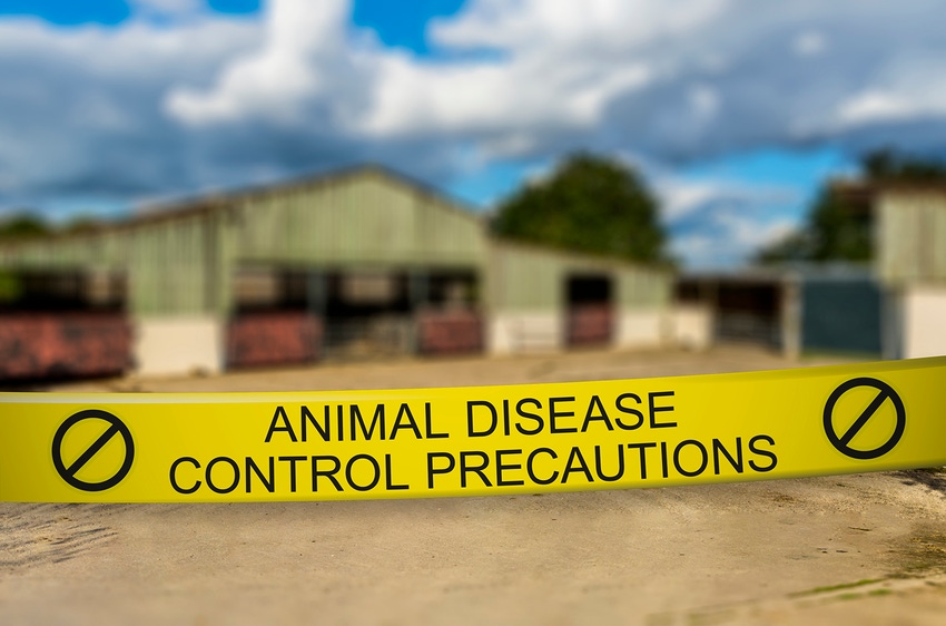 Animal disease control precautions tape in front of a barn