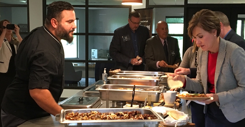 Chef José Mendin describes the variety of authentic Hispanic dishes to Iowa Gov. Kim Reynolds.