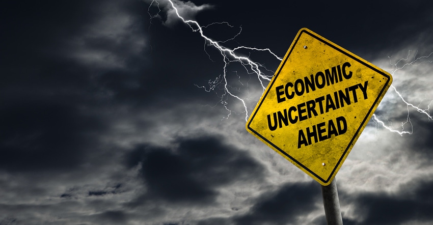Economic uncertainty ahead road sign, storm clouds Economic uncertainty ahead road sign, storm clouds