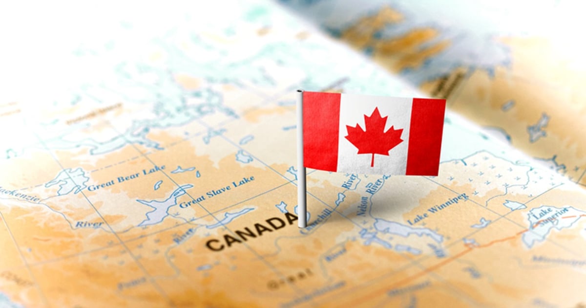 A Canadian flag pinned on a map of Canada