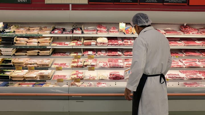 Getty Images Meat Case with Grocery Worker