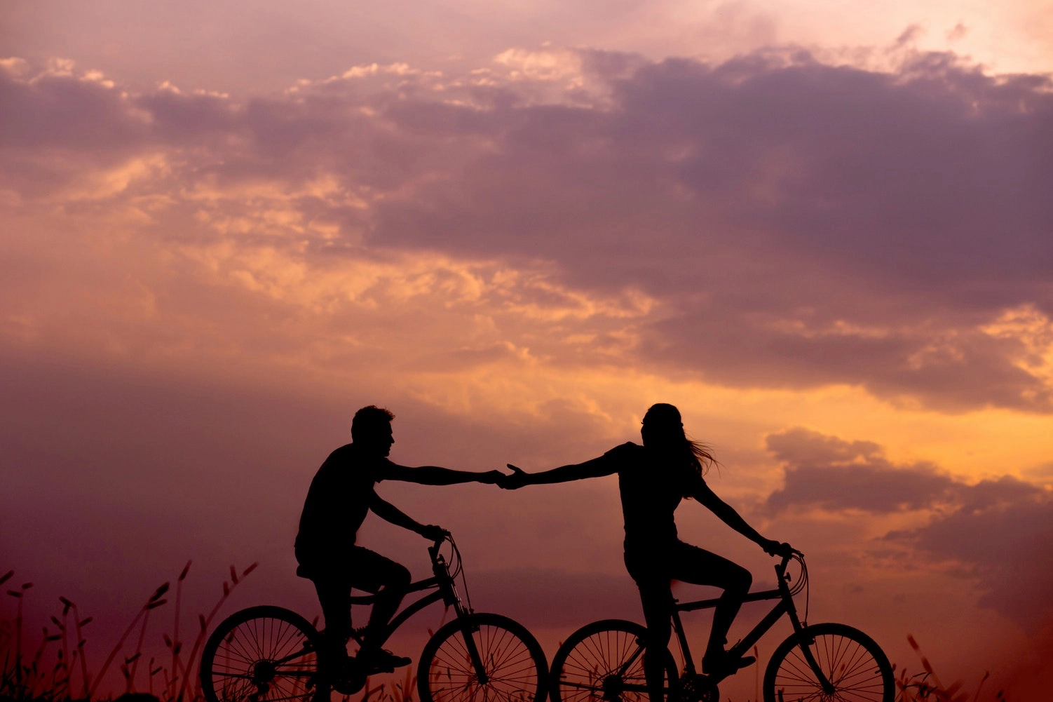 To personer cykler i solnedgang