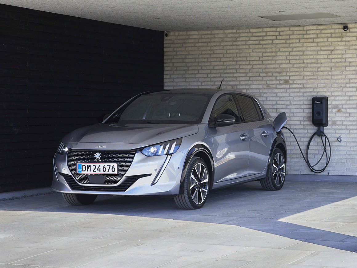 En Peugeot e-208 holder I en indkørelse og lade på en Clever ladeboks