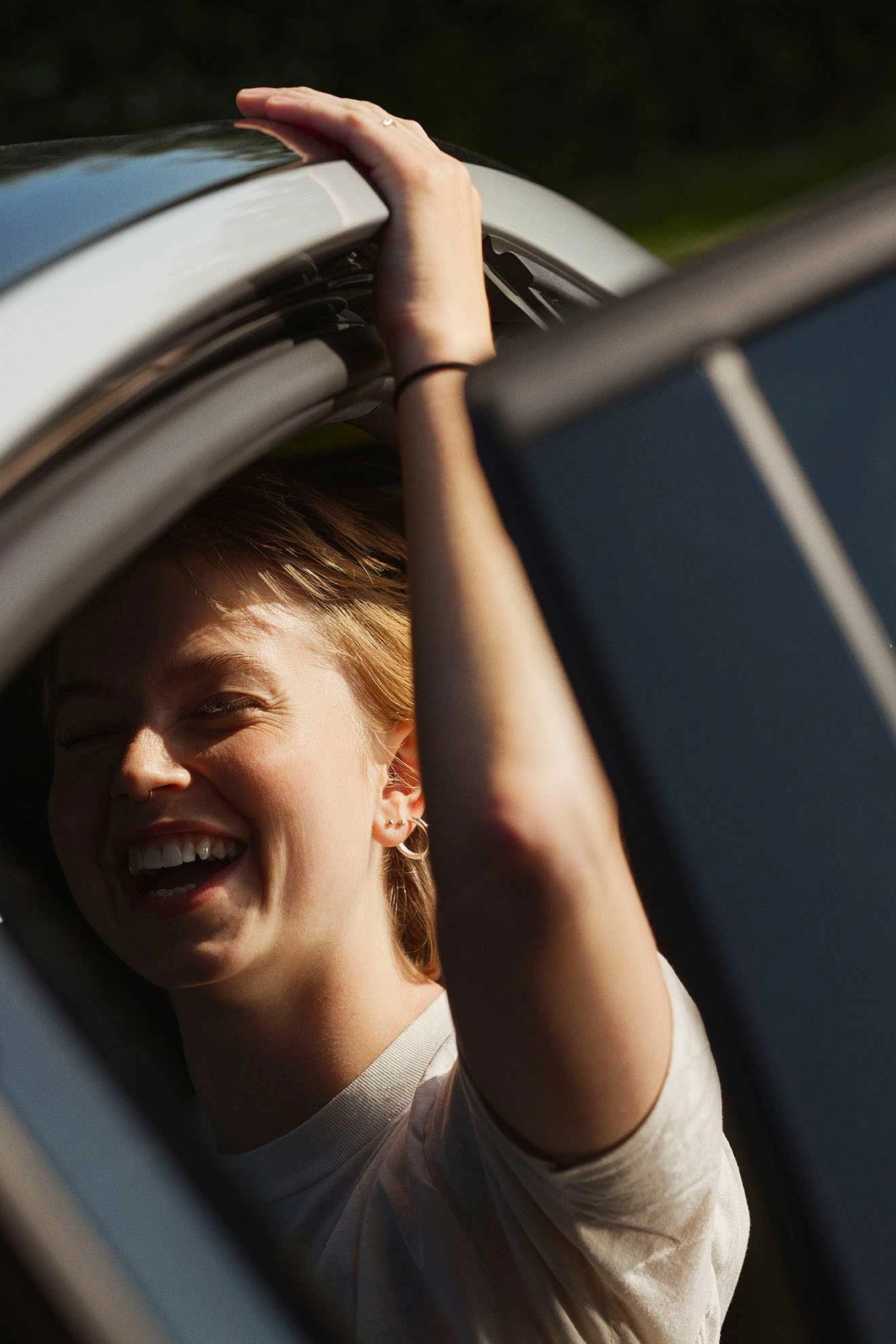Kvinde smiler mens hun sidder i en bil