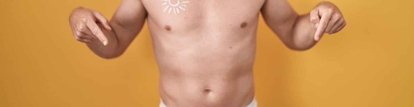 Bare torso with both hands pointing toward the lower abdomen against a yellow background