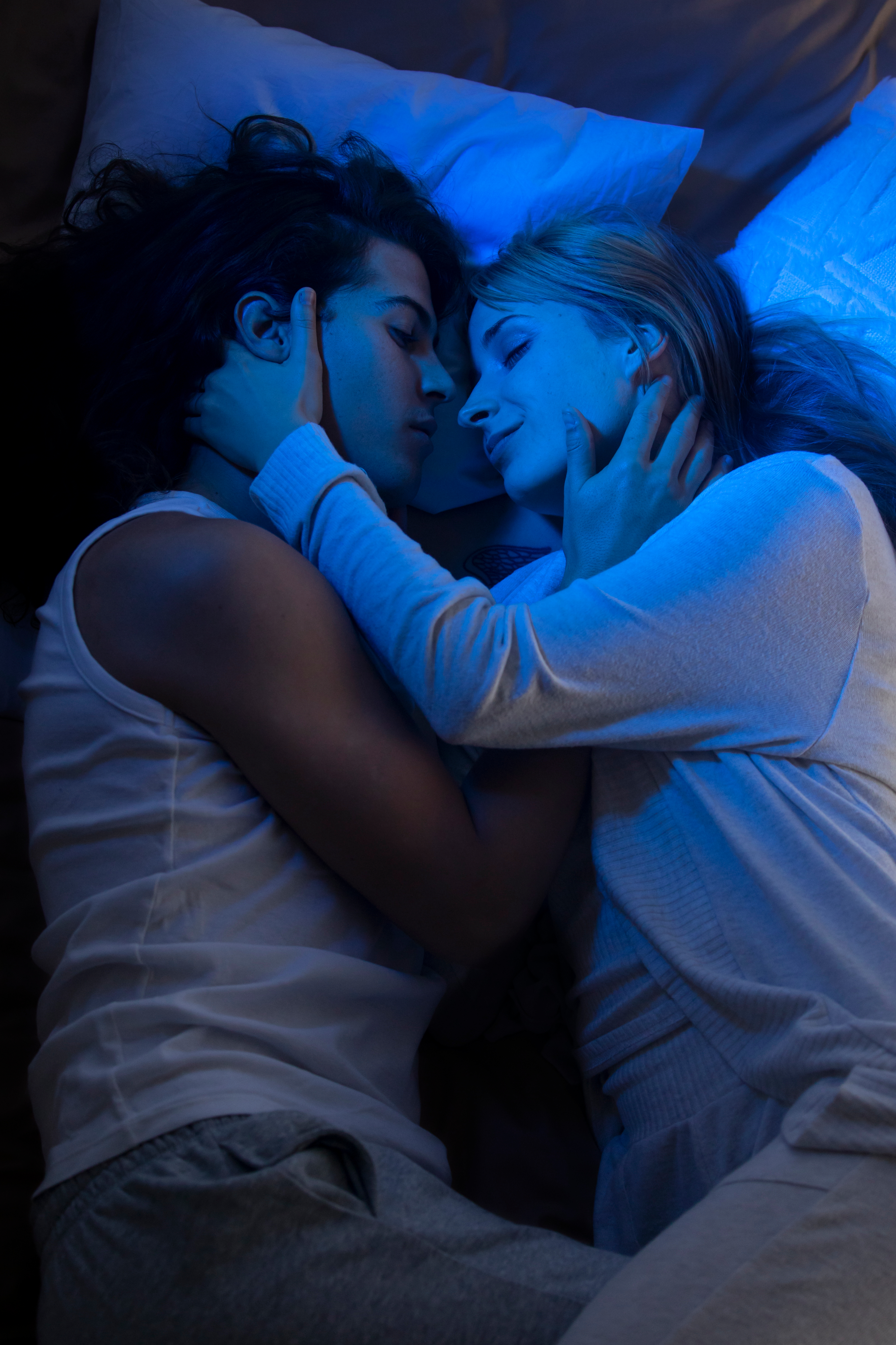 Two people laying on bed together