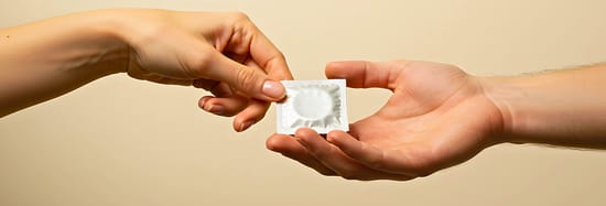 Persona adulta dandole un condon a otra persona adulta