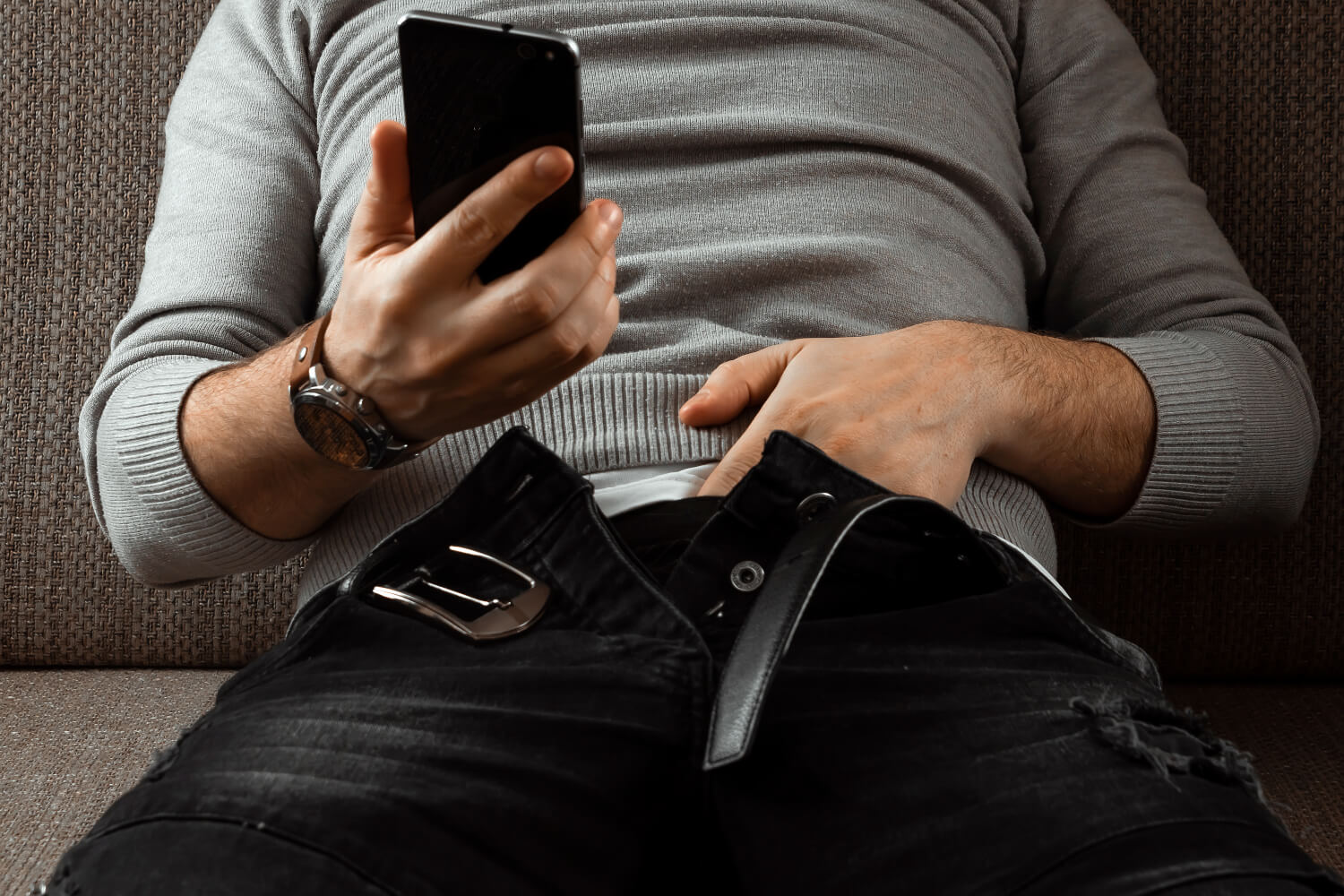 Hombre viendo su celular y tocandose el pene