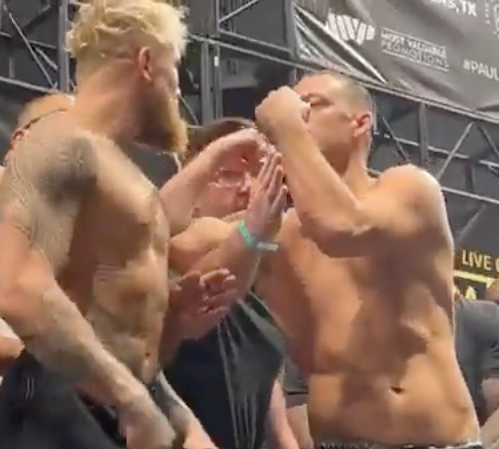 Two MMA fighters surprise crowd as they kiss during pre-fight faceoff