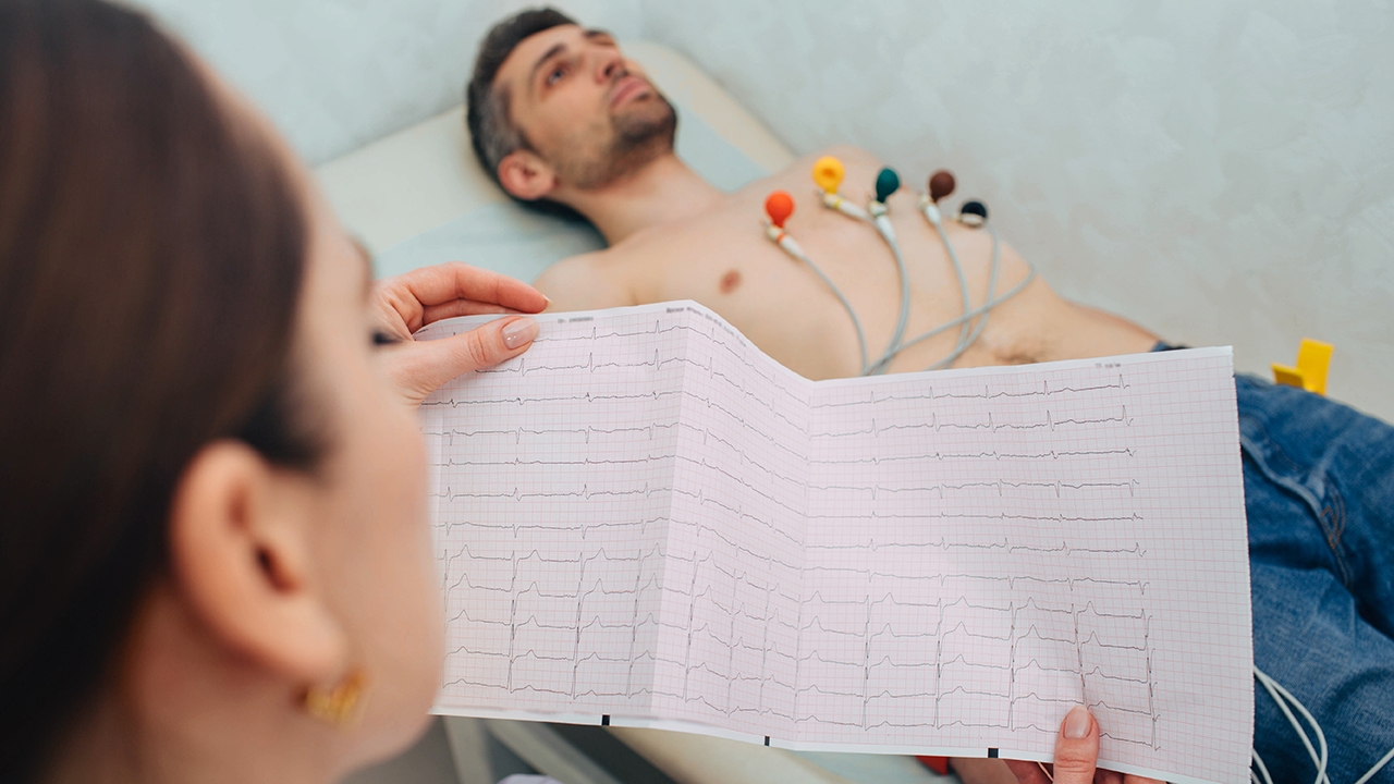 Apparative Untersuchungen am EKG: Ärztin mit männlichem Patient am EKG