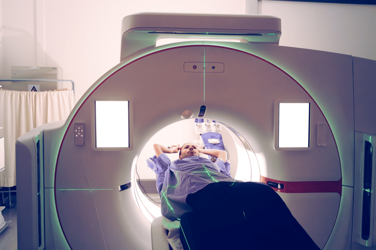 Patientin bei einer CT-Untersuchung zum Lungenkrebsscreening Patientin liegt während des Lungenkrebsscreenings auf der Untersuchungsliege eines Computertomografen.