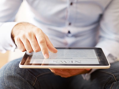 Man liest auf Tablett Neuigkeiten